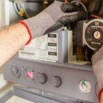 Close-up of hands adjusting a boiler system with precise instrumentation, showing maintenance work. - Photo by Heiko Ruth on Pexels