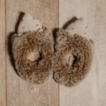 Top view of cute and cozy furry slippers placed on a wooden surface, perfect for warmth and comfort. - Photo by Pavel Danilyuk on Pexels