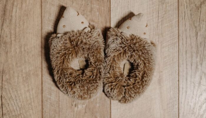 Top view of cute and cozy furry slippers placed on a wooden surface, perfect for warmth and comfort. - Photo by Pavel Danilyuk on Pexels