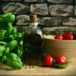 A rustic arrangement of fresh basil, ripe tomatoes, and olive oil on a wooden surface. - Photo by Pixabay on Pexels